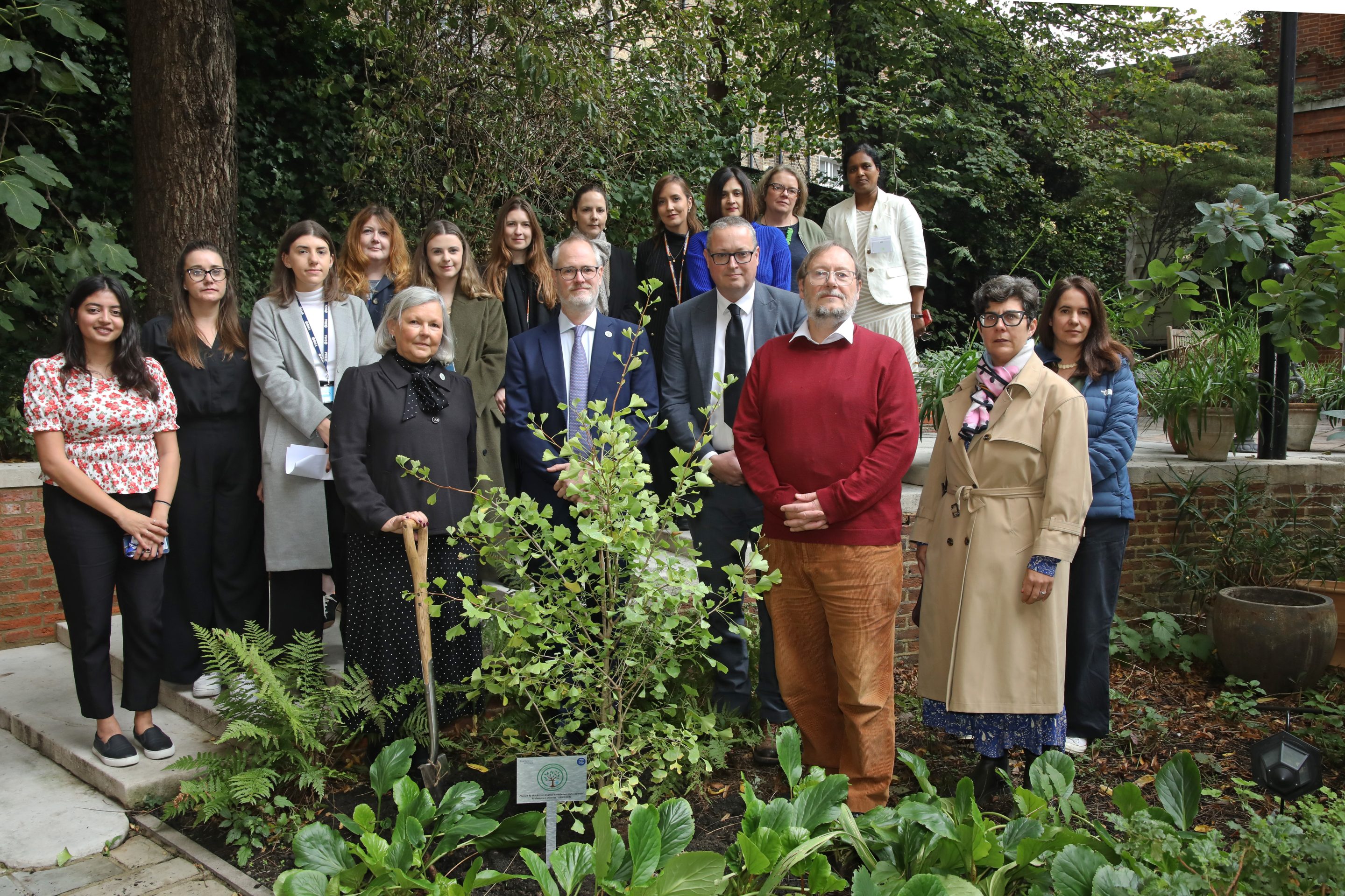 Colleagues at a memorial tree planting in a garden